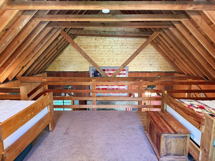 Open loft under exposed beams with beds along both walls